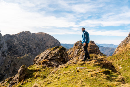 A hiker dressed in blue at the top of the mountain of Aiako Harria or PeÃ±as de Aya in the town of...