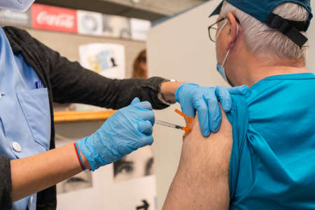 San SebastiÃ¡n, Gipuzkoa. Spain. May 8, 2021: An adult man receiving the jab of the Moderna dose by a young nurse at the vaccination center, covid-19. Coronavirusのeditorial素材