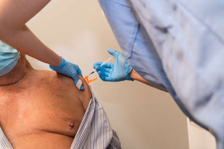 San SebastiÃ¡n, Gipuzkoa. Spain. May 8, 2021: An adult male receiving the jab of the Pfizer dose by a young nurse at the vaccination center, covid-19. Coronavirusのeditorial素材