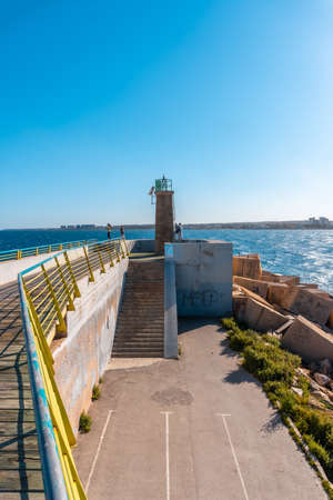 Torrevieja, Alicante. Spain; May 11, 2021: Lighthouse of the breakwater of the coastal city of Torreviejaのeditorial素材