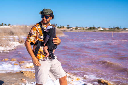 Young father visiting the pink lagoon of Torrevieja, Alicante. Community of Valencia. Spain, holidays in the Mediterraneanの写真素材