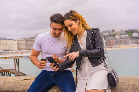 Lifestyle of a couple touring and enjoying the holidays. Looking at the mobile phoneの写真素材