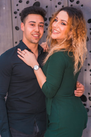 Fashionable pose of a Caucasian loving couple in a blue suit and green dressの写真素材