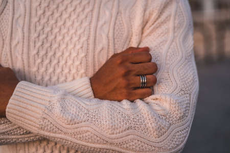 Summer lifestyle, a young Latino enjoying summer vacations. dressed in white with pants and sweater, detail of the handsの写真素材