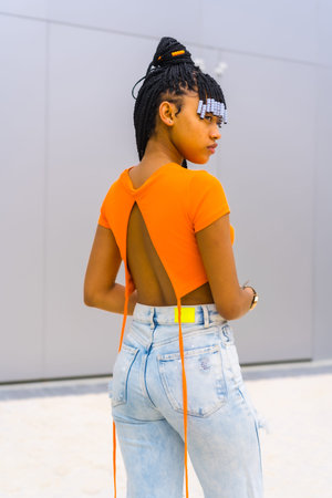 A young trap dancer with braids. Black ethnic girl with orange t-shirt and cowboy pants. I posed...