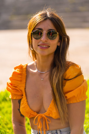Lifestyle of a young caucasian brunette enjoying the summer in a park in the city. Girl with...