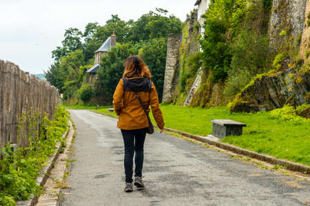 A young woman walking along the walls of the Castle of Vitre. Ille-et-Vilaine department, Brittany region, Franceのeditorial素材