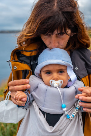 A young mother with her baby at the Phare Du Cap Frehel is a maritime lighthouse in Cotes-dÂ´Armor (France). At the tip of Cap Frehelの写真素材