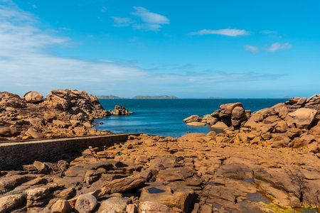 Coast at low tide along Mean Ruz lighthouse, port of Ploumanach, in the town of Perros-Guirec, Cotes-d'Armor, in French Brittany, France.の写真素材