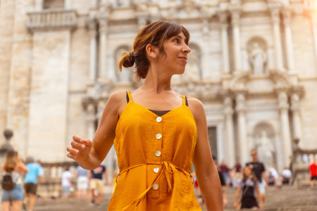Girona medieval city, a young orange tourist on vacation at the Girona Cathedral, Catalonia's Costa...