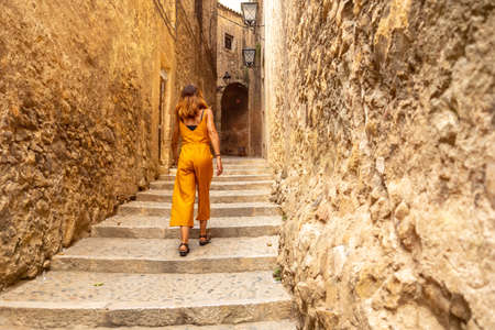 Girona medieval city, a young woman climbing the stairs of the streets of the historic center, Costa Brava of Catalonia in the Mediterranean. Spainの写真素材