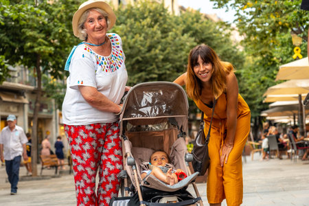 Girona medieval city, mother, grandmother and grandson enjoying the summer holidays walking,...