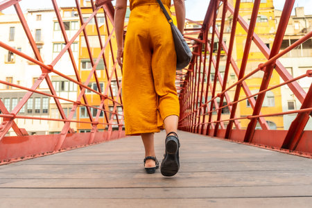 Girona medieval city, a young tourist walking on the famous red bridge Pont de les Peixateries...