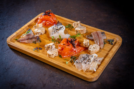 Smoked table on a black background, sea food, variety of fish and seafoodの写真素材