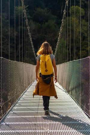 A hiker crossing the Holtzarte suspension bridge, Larrau. In the forest or jungle of Irati, Pyrenees-Atlantiques of Franceの写真素材