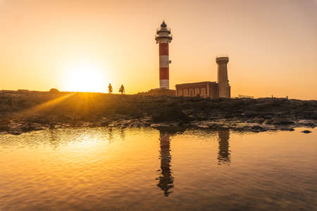 Silhouette a couple in the Sunset at the Toston Lighthouse, Punta Ballena near the town of El Cotillo, Fuerteventura Island, Canary Islands. Spainの写真素材