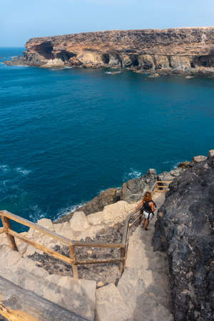 A young woman on the stairs of the path towards the caves of Ajuy, Pajara, west coast of the island of Fuerteventura, Canary Islands. Spainの写真素材
