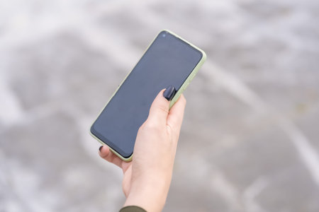 Hands of an unrecognizable person with a mobile phone in hand