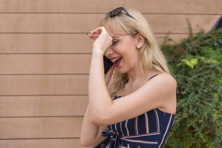 Entrepreneur girl in a business park, young blonde smiling making a call with the phoneの写真素材