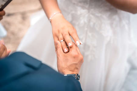 Man putting the wedding ring to the bride at the wedding ceremony, essential moments in a couple's relationship, photos at the wedding celebrationの写真素材