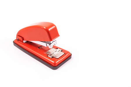Detail of a red handheld stapler on a white background, copy and paste spaceの写真素材