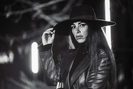 Girl in a hat at night in a park. Black and white photoの写真素材