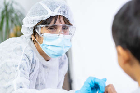 Female doctor bumping a child after the vaccine. Vaccination of children. Immunization in the coronavirus pandemic, covid-19の写真素材