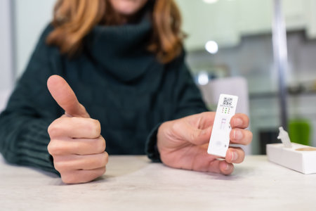 Happy with the negative test result. A young woman doing the rapid antigen test at her home,...