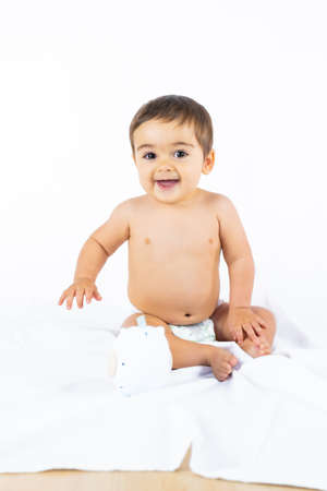 Baby boy in a studio with a white background, newborn caucasian eight months old smiling, vertical photoの写真素材