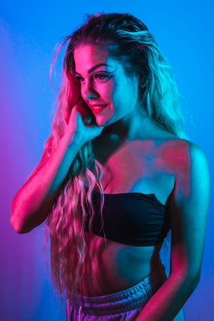 A Caucasian blonde girl in a nightclub with eye drawing makeup, eyelashes arranged on a blue...