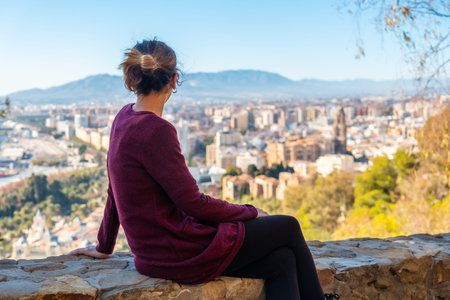 A young tourist sitting looking at the views of the city and the Cathedral of the Incarnation of...