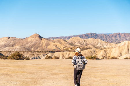 A young woman walking in the Las Salinas ravine on a trek in the Tabernas desert, AlmerÃ­a...