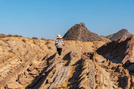 A young hiker girl in Colas de Dragon in the desert of Tabernas, AlmerÃ­a province, Andalusia. Trekking in the desert, lifestyleの写真素材