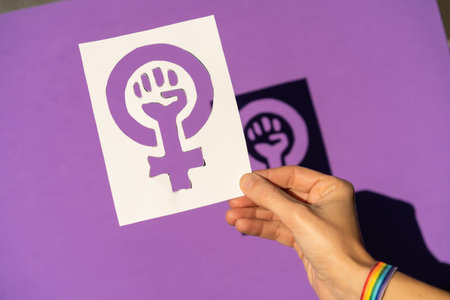 A woman holding a drawing in a vindication in favor of equality between men and women, purple background, fighting in favor of women, Female Forceの写真素材