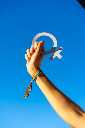 A woman with female symbol in favor of feminism, blue sky background, fighting in favor of women,...
