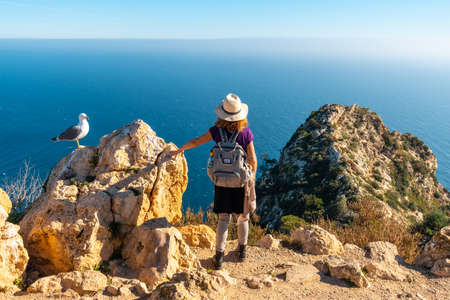 A young hiker at the Mirador de Carabineros in the Penon de Ifach Natural Park in the city of Calpe, Valencia, Valencian Community. Spain. mediterranean seaの写真素材