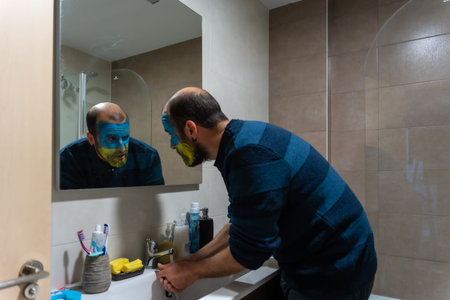 Stop war, conflict between Ukraine and Russia. Portrait of a young man with his face painted in the...
