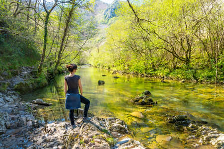 A young woman in the Sella river between the Tornin to the Olla de San Vicente, near Cangas de Onis. Asturias. Spainの写真素材