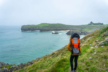 A young woman with her son walking towards Playa de Troenzo and Playa de la Tayada on the Borizu peninsula in the town of Llanes. Asturias. Spainの写真素材