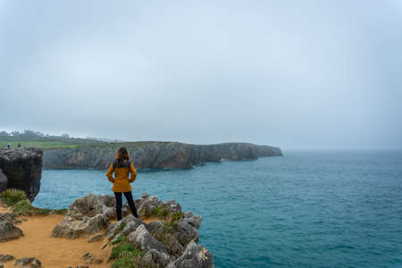 A young tourist looking at the Jesters of Pria in the town of Llanes. Asturias. Spainの写真素材