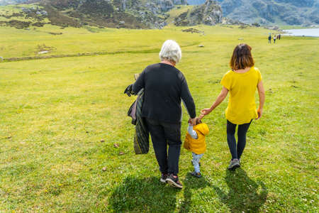 Grandmother, mother and son sightseeing at Lake Ercina in the Lakes of Covadonga. Asturias. Spainの写真素材