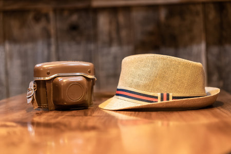 Vintage camera and a hat on a table, travel photography concept, digital nomad life, digital content creator, film camera and a straw hatの写真素材