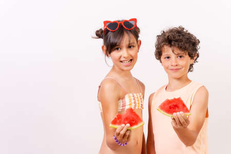 Caucasian children eating a watermelon in the summer heat, school vacation concept. white backgroundの写真素材