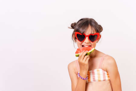 Girl enjoying the summer eating a watermelon, school vacation concept. white backgroundの写真素材