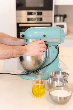 A man baker cooking a red velvet cake at home, preparing the cake in the kitchen robot, work at homeの写真素材