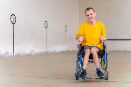 A disabled person in a wheelchair at a Basque ball game fronton