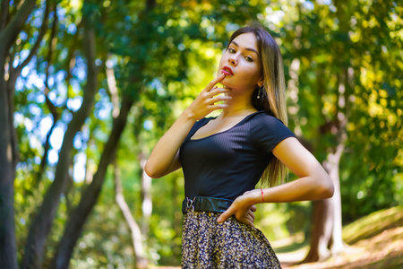 Portrait of a young brunette woman in nature in the natural park in autumn, freedom
