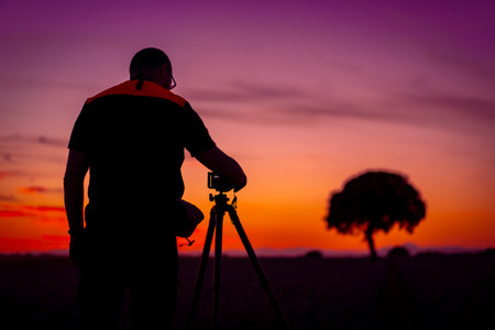 A photographer taking photos at sunset in a lavender field, nature photography