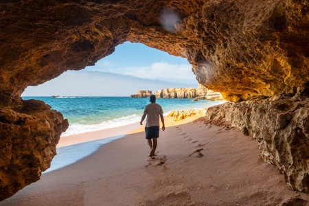 A man in the beach cave at Praia da Coelha, Algarve, Albufeira. Portugalの写真素材
