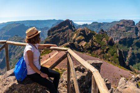 A tourist sitting looking at the mountains in the mountains at Pico do Arieiro, Madeira. Portugalの写真素材